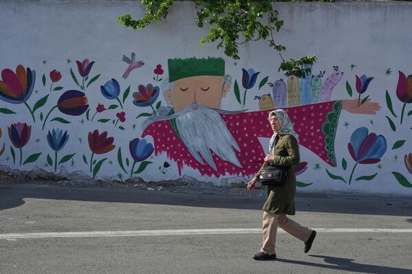 Жена пролази поред слике на зиду у јужном делу Техерана. - Sputnik Србија