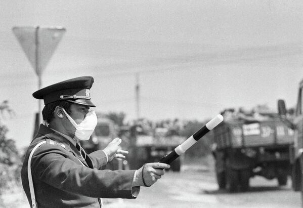 Службеник Државног инспектората за безбедност саобраћаја Министарства унутрашњих послова СССР-а прати кретање возила из подручја поред Чернобиљске нуклеарне електране. - Sputnik Србија