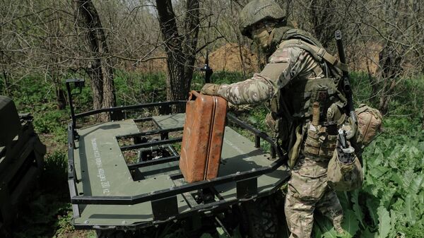 Voennoslužaщiй gruppirovki voйsk Dnepr zagružaet pripasы na nazemnый robototehničeskiй kompleks Kurьer  - Sputnik Srbija