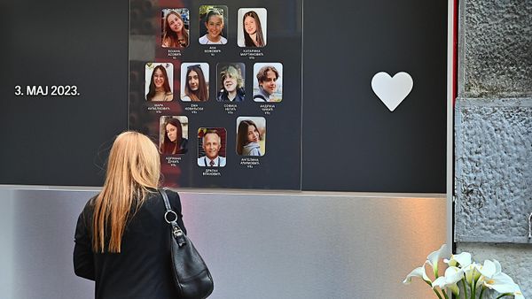 Жена одаје пошту испред Спомен-обележје у Основној школи Владислав Рибникар у Београду - Sputnik Србија
