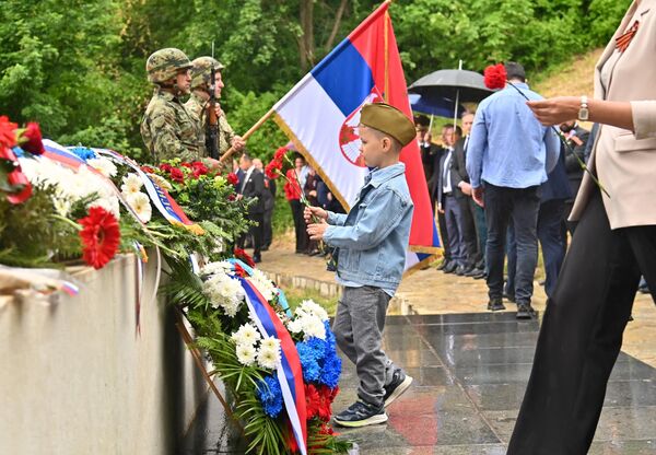 Dečak sa kapom sovjetskog vojnika ostavlja karanfile na spomen obeležje - Sputnik Srbija