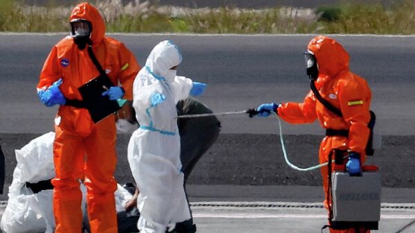 Passažir kruiznogo laйnera MV Hondius, na bortu kotorogo proizošla vspыška hantavirusa, prohodit dezinfekciю na vzletno-posadočnoй polose aэroporta Tenerife-Юžnый (Kanarskie ostrova, Ispaniя) - Sputnik Srbija