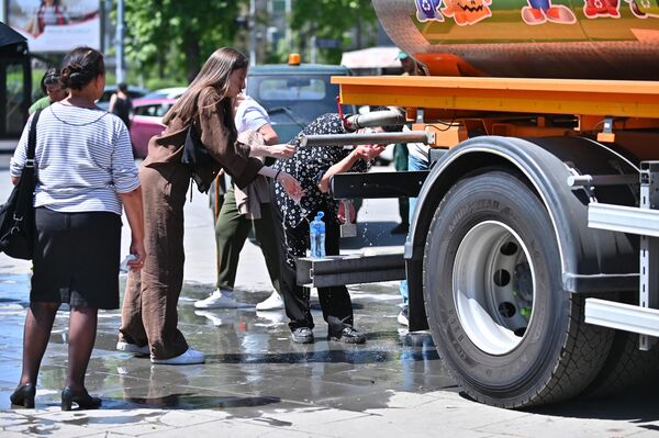 У близини Храма паркиране су цистерне са водом како би се верници освежили - Sputnik Србија
