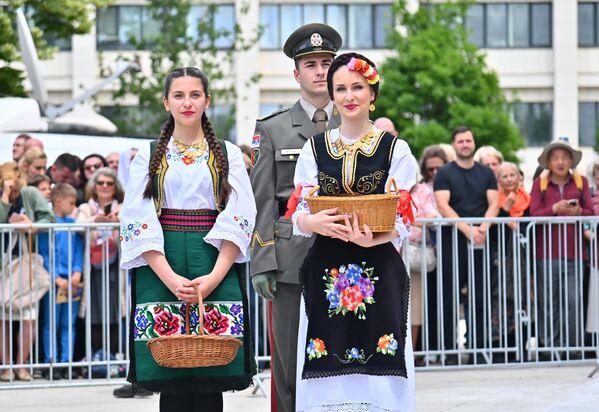 Девојке у народној ношњи са корпама пуним латица цвећа којима ће засипати светињу  - Sputnik Србија