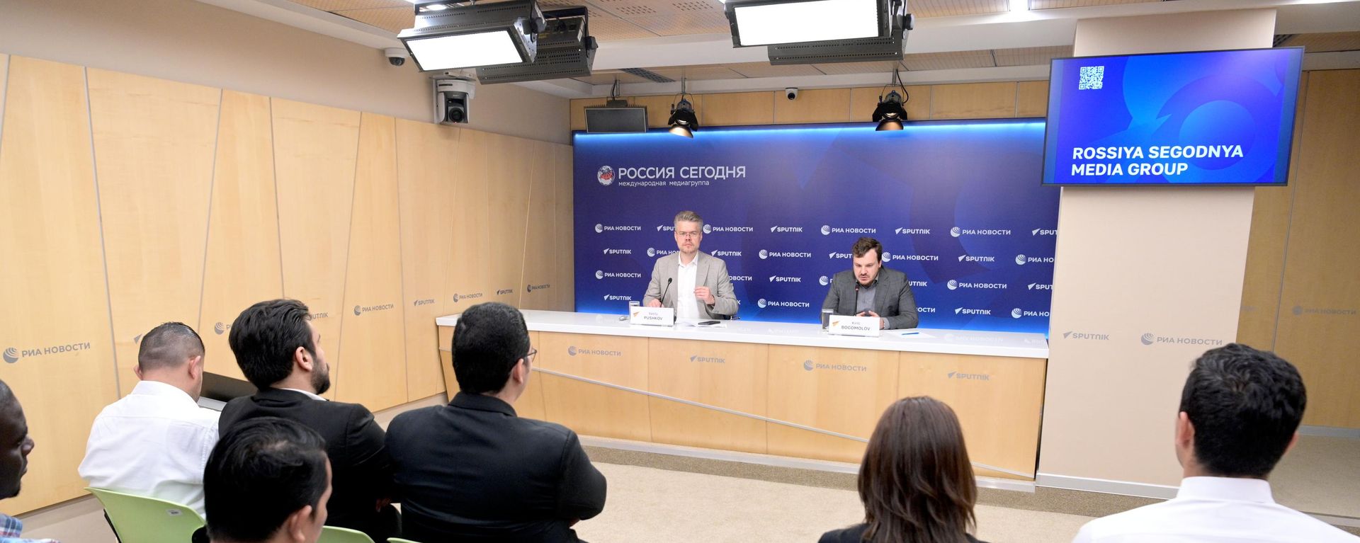 Direktor za međunarodnu saradnju medijske grupe Rusija sevodnja Vasilij Puškov i zamenik direktora Rossotrudničestva Kiril Bogomolov govore na radionici programa SputnikPro AI in Media - Sputnik Srbija, 1920, 23.06.2026