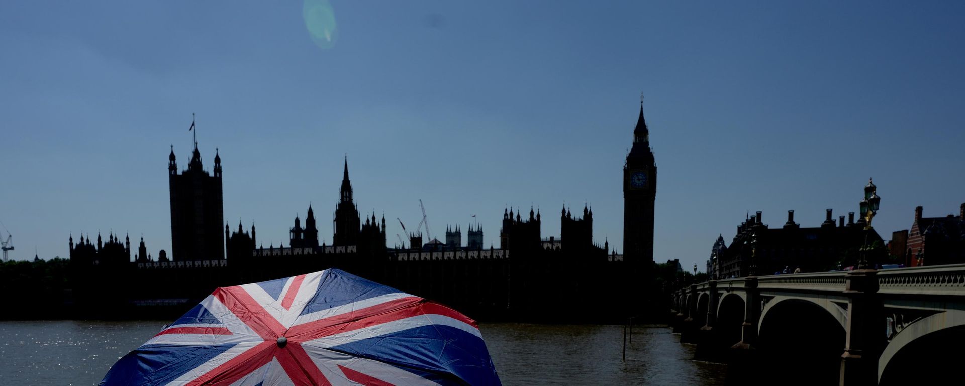 Turista sa kišobranom u bojama britanske zastave ispred Big Bena u Londonu  - Sputnik Srbija, 1920, 28.06.2026