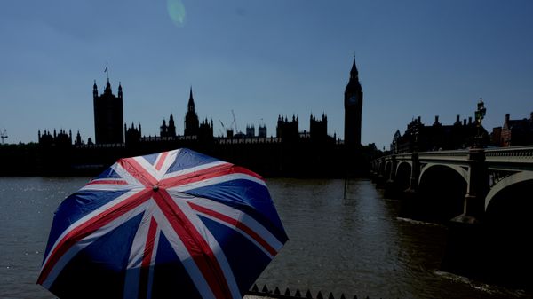 Turista sa kišobranom u bojama britanske zastave ispred Big Bena u Londonu  - Sputnik Srbija