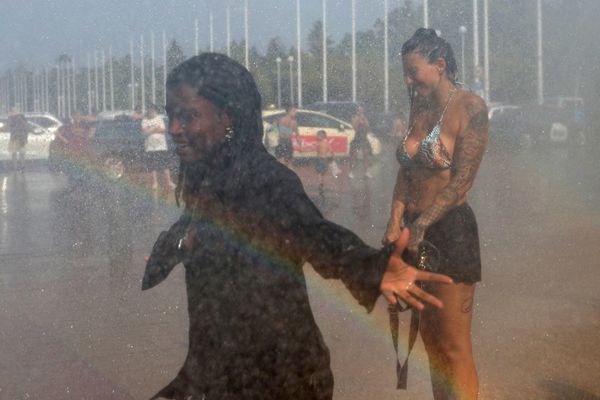 Људи уживају у води коју распршује полицијски водени топ испред Олимпијског стадиона током топлотног таласа који је захватио Берлин, Немачка, 28. јуна 2026. године. - Sputnik Србија