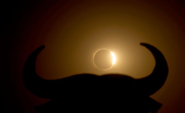 Mesec delimično prekriva Sunce tokom pomračenja, u blizini siluete Osbornovog bika, u Navareteu, na severu Španije. - Sputnik Srbija