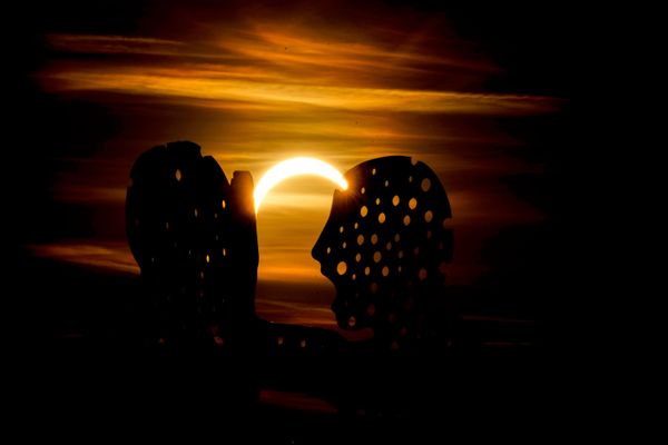Mesec delimično prekriva Sunce tokom pomračenja u blizini skulpture „Čovek-molekul“ u Berlinu. - Sputnik Srbija