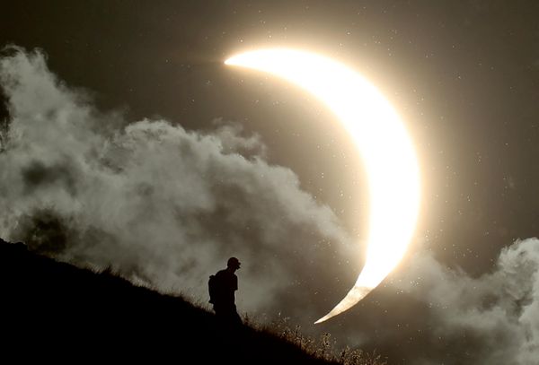 Osoba posmatra delimično pomračenje Sunca sa Glastonberi Tora u Glastonberiju. - Sputnik Srbija