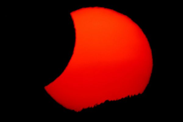 Mesec delimično prekriva Sunce dok zalazi, nakon potpunog pomračenja Sunca, snimljenog iz Arije u Španiji. - Sputnik Srbija