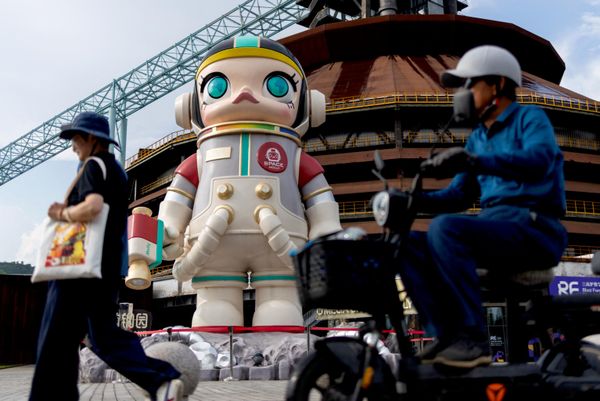 Ljudi prolaze pored ogromne figure lika „Spejs Moli“ („Space Molly“) iz serije umetničkih igračaka „Pop Mart“ u pekinškom parku Šougang, u Kini. - Sputnik Srbija