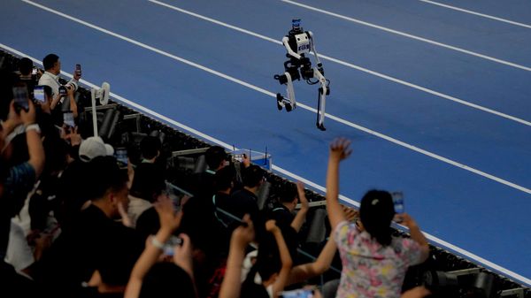 Zriteli podbadrivaюt robota, učastvuющego v zabege na 1500 metrov vo vremя Vsemirnыh igr čelovekopodobnыh robotov v Pekine - Sputnik Srbija