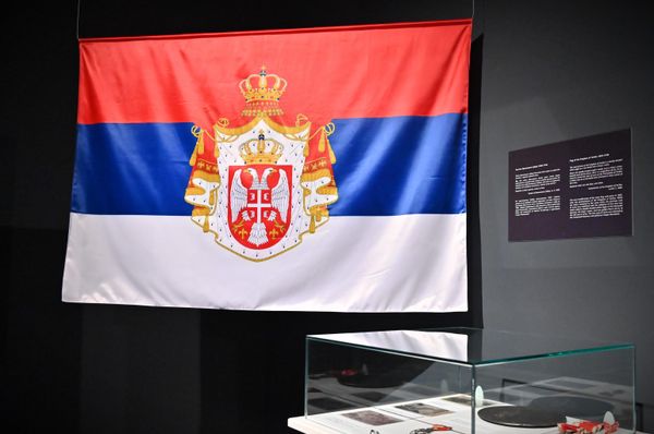 Застава Краљевине Србије (1882–1918) са препознатљивом црвено-плаво-белом тробојком и краљевским грбом који садржи двоглавог белог орла, круну и краљевски плашт. - Sputnik Србија
