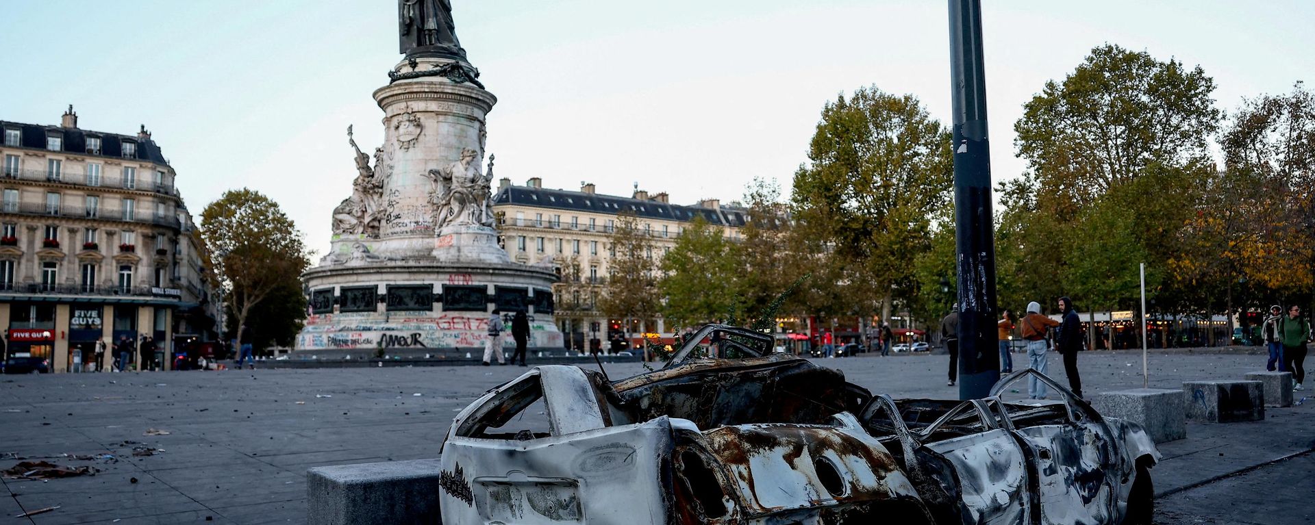 A destroyed car near the Marianne statue at the Place de la Republique, with a yellow vest put on it, the day after clashes during a national day of demonstrations against the cost of living and rising fuel prices, in Paris, France, October 18, 2026 - Sputnik Srbija, 1920, 18.10.2026