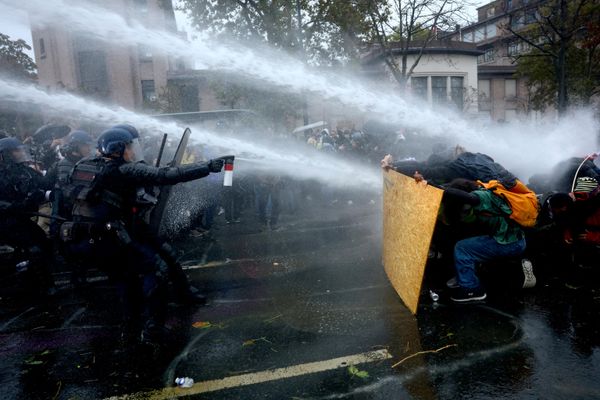 Демонстранти се заклањају док француска интервентна полиција и жандармерија користе водени топ током сукоба на одобреном протесту који су организовали синдикати у Паризу, у оквиру националних протеста покрета „Жути прслуци“, којима су се придружили средњошколци и студенти, а против трошкова живота и раста цена горива. - Sputnik Србија