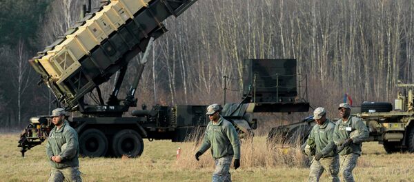 U.S soldiers walk next to a Patriot missile defence battery during join exercises at the military grouds in Sochaczew, near Warsaw - Sputnik Србија