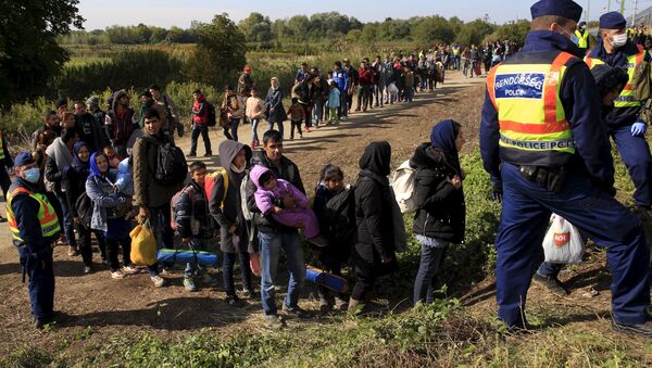 Izbeglice iz Sirije čekaju ukrcavanje na voz u Mađarskoj 1. oktobra 2015. - Sputnik Srbija