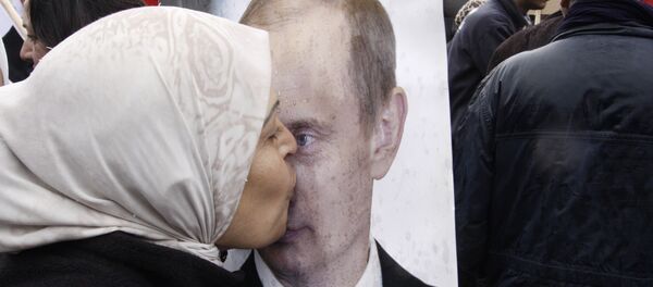 Sirijka ljubi poster na kojem je fotografija ruskog predsednika Vladimira Putina - Sputnik Srbija