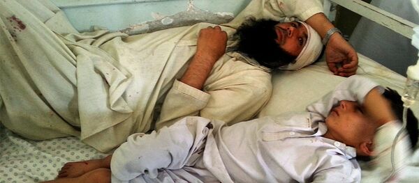 Авганистанац и дете леже на кревету након што су рањени у експлозији у провинцији Кунар, Авганистан, у недељу, септембар 20, 2015. - Sputnik Србија