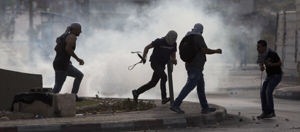 Палестинци беже од сузавца током сукоба за Израелским трупама Палестинци беже од сузавца током сукоба за Израелским трупама - Sputnik Србија