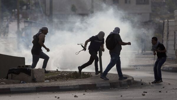 Палестинци беже од сузавца током сукоба за Израелским трупама - Sputnik Србија