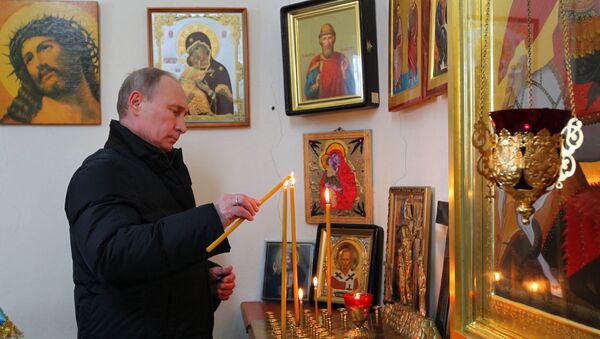Председник Русије Владмир Путин у цркви пали свеће - Sputnik Србија