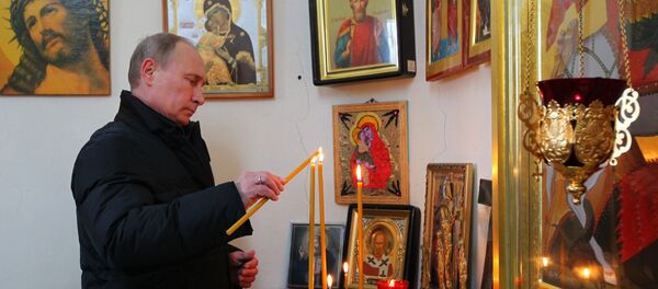 Predsednik Rusije Vladmir Putin u crkvi pali sveće - Sputnik Srbija