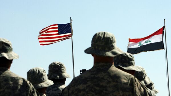 Američki vojnici stoje u stavu mirno ispred američkih i iračkih (D) zastavama tokom ceremonije primopredaje u blizini iračkog grada Havija - Sputnik Srbija