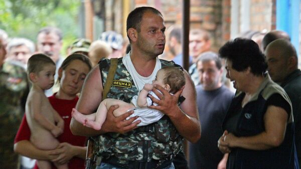 Припадник руске специјалне службе носи бебу након терористичког напада у Беслану - Sputnik Србија