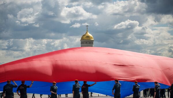Запослени у Министарству за ванредне ситуације развијају велику руску заставу - Sputnik Србија