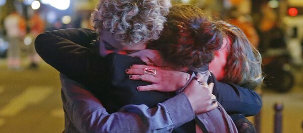 People hug on the street near the Bataclan concert hall following fatal attacks in Paris, France, November 14, 2015 - Sputnik Србија