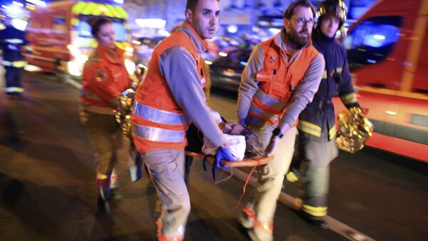 Евакуација жене из Батаклан позоришта након пуцњаве у Паризу, петак 13. новембар 2015 - Sputnik Србија
