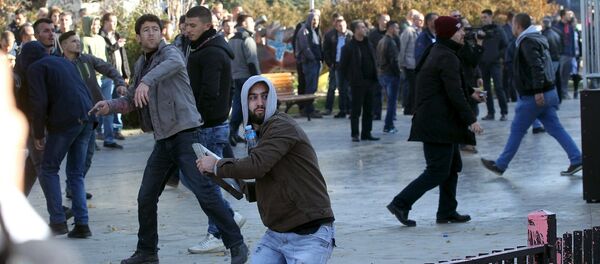 Присталица опозиционих странака на Косову баца камен ка полицији на демонстрацијама у Приштини - Sputnik Србија