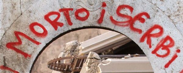 Албанка пролази испод натписа Смрт за Србе ишараног на згаришту древног православног манастира у Призрену, после погрома 17. марта 2004. године Албанка пролази испод натписа Смрт за Србе ишараног на згаришту древног православног манастира у Призрену, после погрома 17. марта 2004. године - Sputnik Србија