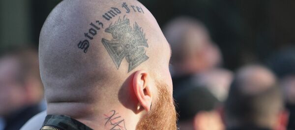 Припадник деснице на протесту са тетоважом Поносан и слободан. - Sputnik Србија