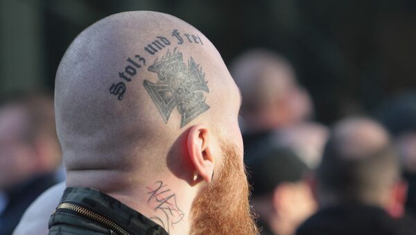 Припадник деснице на протесту са тетоважом Поносан и слободан. - Sputnik Србија