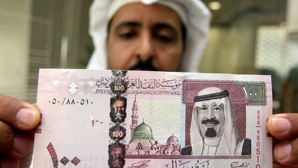Saudijski bankar prikazuje novu novčanicu od sto saudijskih riala sa portretom Saudijskog kralja Abdulaha bin Abdul Aziz el Saud u banci u Rijadu, 05. juna 2007. godine - Sputnik Srbija