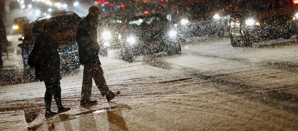 People cross a street as it snows in Washington People cross a street as it snows in Washington - Sputnik Srbija