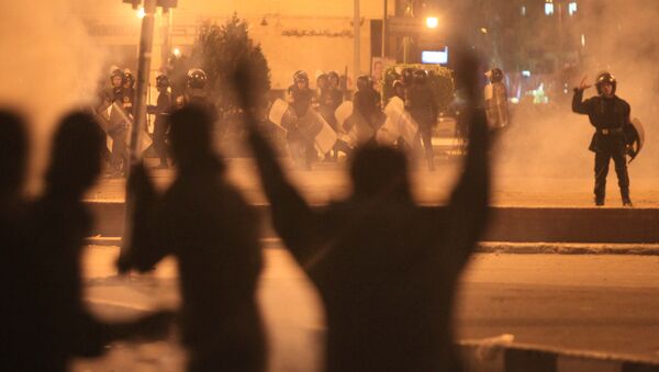 Egyptian protesters gesture as they clash with riot police at Cairo's landmark Tahrir Square on November 19, 2011, as Egyptian police fired rubber bullets and tear gas to break up a sit-in among whose organisers were people injured during the Arab Spring which overthrew veteran president Hosni Mubarak - Sputnik Србија