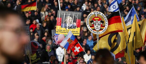 Demonstarnti u Drezdenu nose transparente protiv kancelarke Angele Merkel - Sputnik Srbija