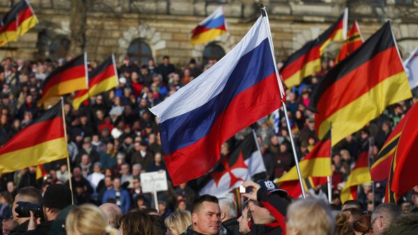 Демонстарнти носе заставе против канцеларке Ангеле Меркел - Sputnik Србија