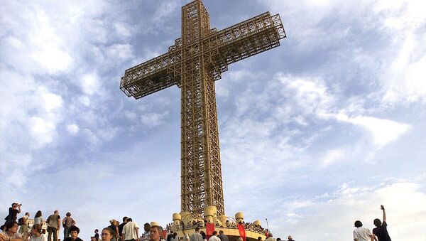 Македонски православни верници седе око масивног металног крста током церемоније освештавања на врху брда Водно у близини Скопља, 28. августа 2002. - Sputnik Србија