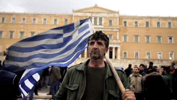 Čovek nosi grčku zastavu ispred zgrade parlamenta Grčke - Sputnik Srbija