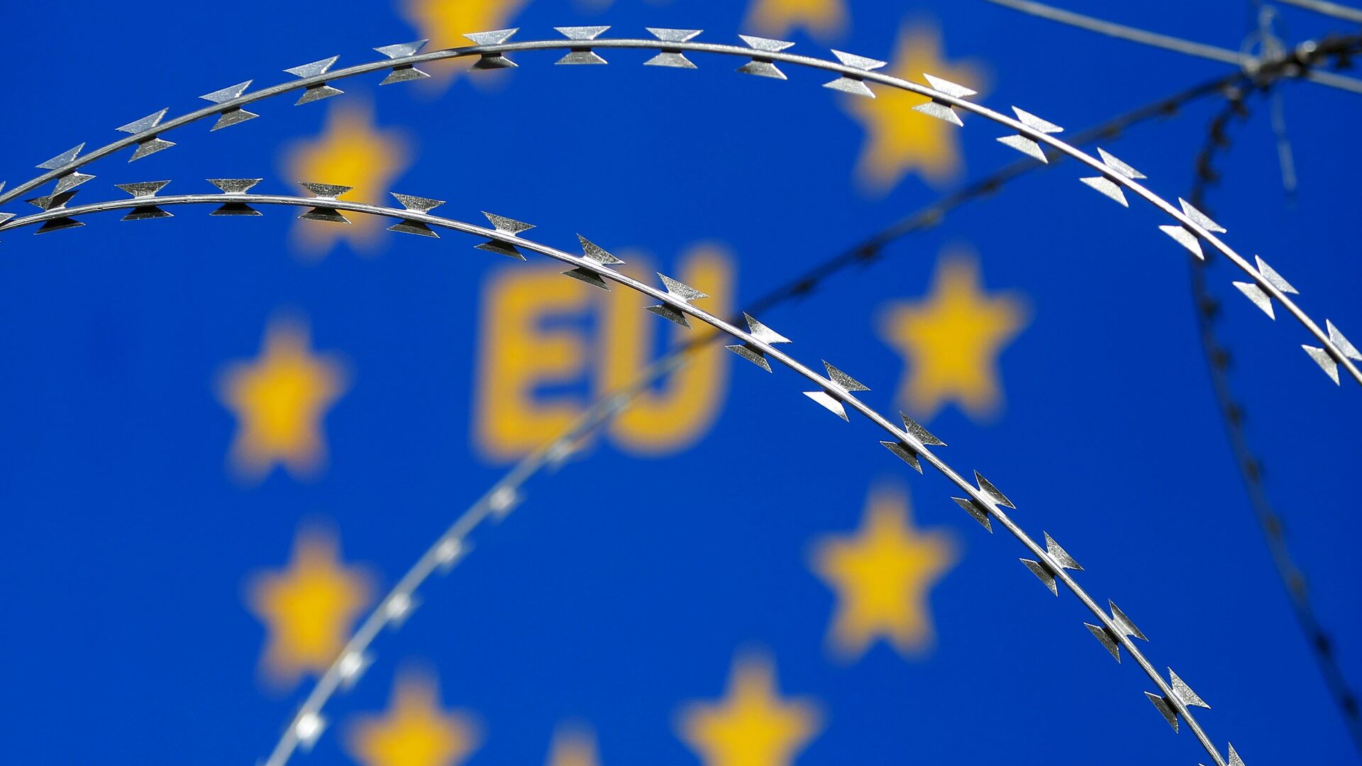 Бодљикава жица се види испред заставе Европске уније (ЕУ) - Sputnik Србија, 1920, 13.08.2021