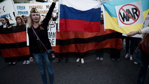 Ljudi drže ruske i ukrajinske zastave povezane i šalju anti-ratne poruke - Sputnik Srbija