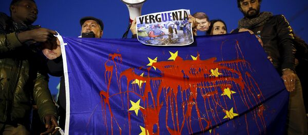 Demonstranti drže zastavu Evropske unije umrljanu farbom i učestvuju u protestu protiv evropske politike za izbeglice u Madridu 11. mart 2016. godine - Sputnik Srbija