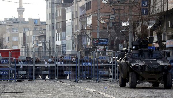 Ljudi iza zida koji čuva policija u Turskom gradu Dijarbakir dana 16. marta - Sputnik Srbija
