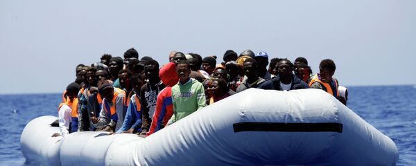 Група избеглица из Африке снимљена у чамцу за спасавање на Медитерану у близини либијске обале. - Sputnik Србија